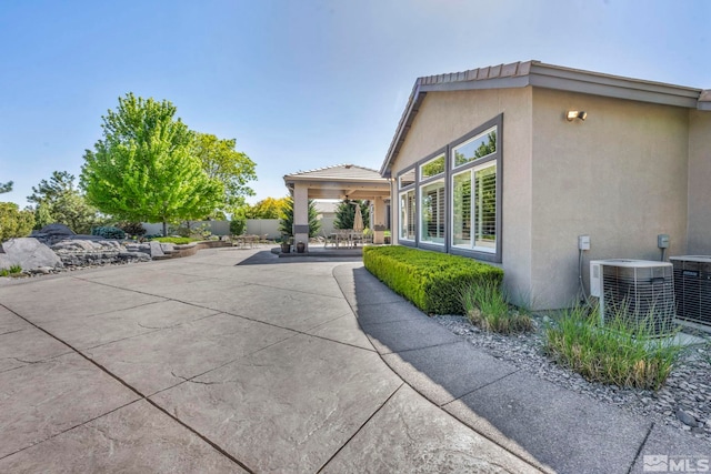 view of property exterior with a patio and central AC