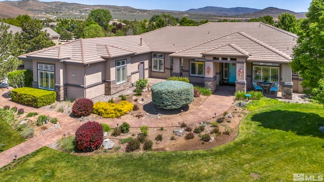 view of front of home with a front lawn and a mountain view