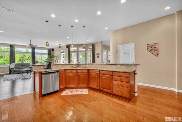 kitchen featuring dishwasher, hanging light fixtures, light stone countertops, and light hardwood / wood-style floors