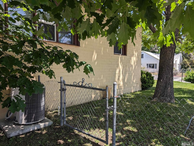 view of side of property with central air condition unit and a lawn