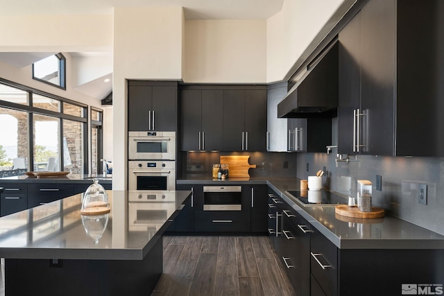 kitchen with black electric cooktop, dark wood-type flooring, backsplash, lofted ceiling, and double oven