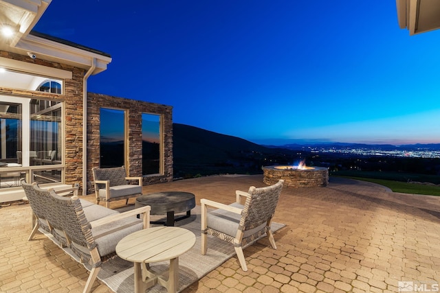 view of patio / terrace with an outdoor living space with a fire pit and a mountain view