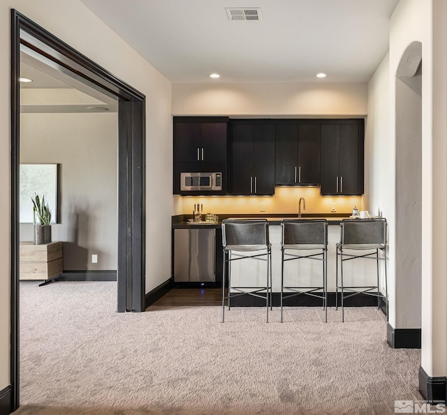 kitchen featuring appliances with stainless steel finishes, carpet, and sink