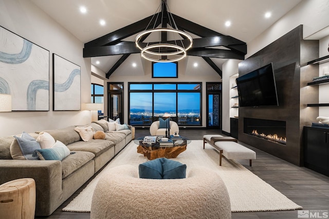 living room with dark wood-type flooring, a large fireplace, vaulted ceiling, and an inviting chandelier