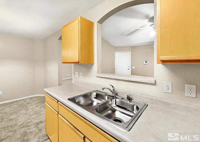 kitchen featuring light brown cabinets, ceiling fan, sink, and light colored carpet