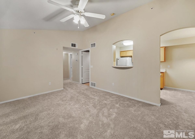 empty room with carpet, ceiling fan, and high vaulted ceiling