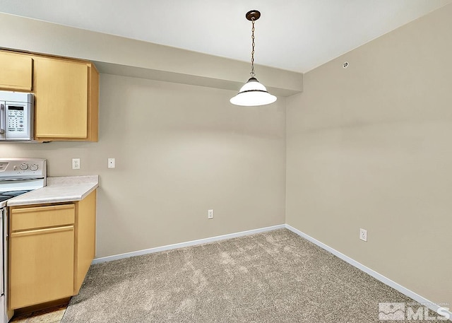 kitchen featuring hanging light fixtures, stainless steel microwave, electric stove, light brown cabinetry, and light colored carpet