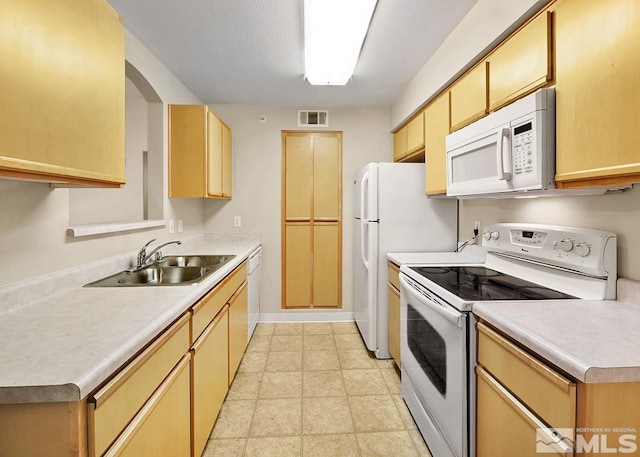 kitchen with sink, white appliances, and light tile floors