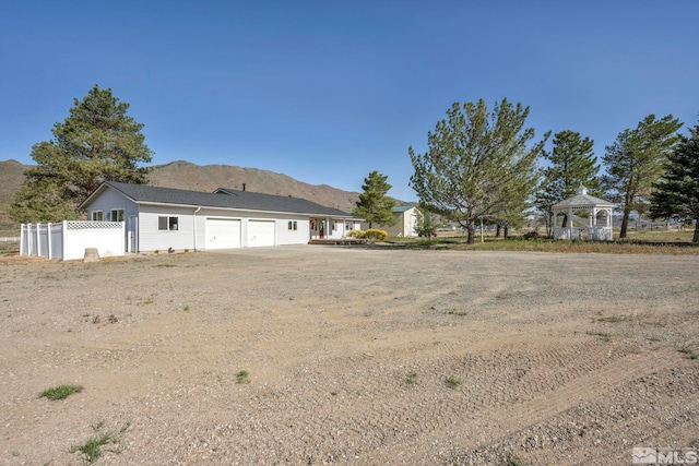 rear view of property with a mountain view and a gazebo