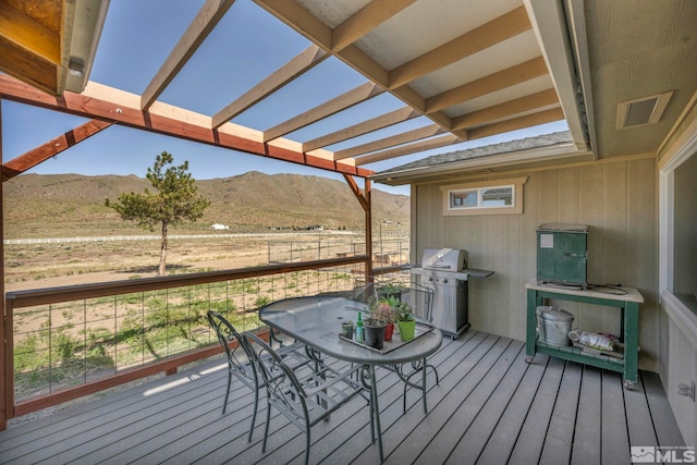 deck featuring area for grilling, a pergola, and a mountain view