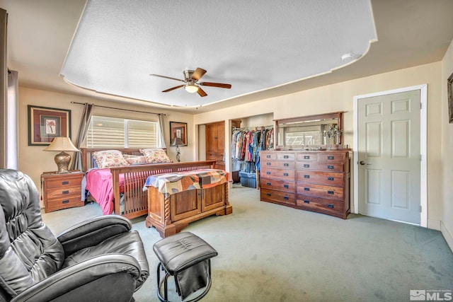 bedroom with carpet, ceiling fan, a closet, and a textured ceiling