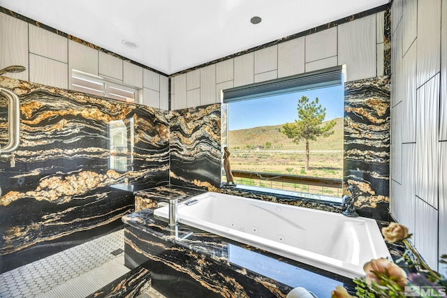 bathroom with a healthy amount of sunlight and tile walls