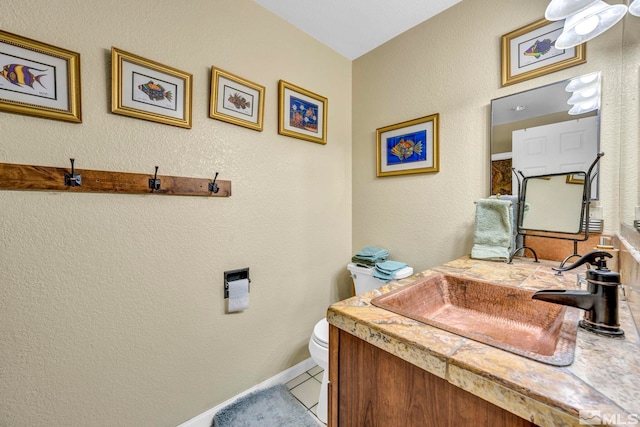 bathroom with vanity, toilet, and tile floors