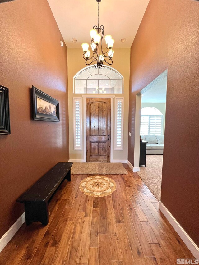 entrance foyer featuring wood-type flooring and an inviting chandelier