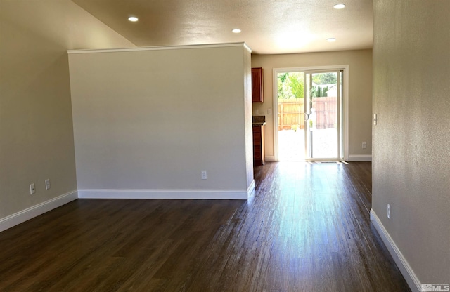 unfurnished room featuring a textured ceiling and dark wood-type flooring