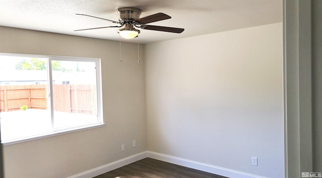 spare room featuring a textured ceiling, dark wood-type flooring, and ceiling fan