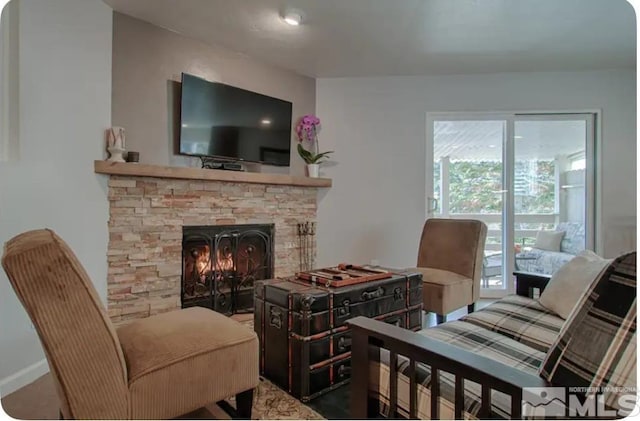 living room featuring a stone fireplace