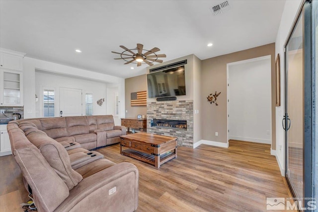 living room featuring ceiling fan and light hardwood / wood-style floors