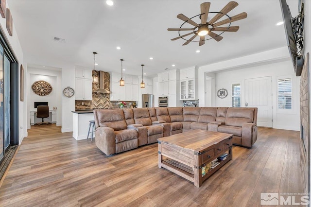 living room featuring ceiling fan and light hardwood / wood-style floors