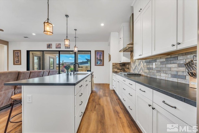 kitchen featuring pendant lighting, a kitchen breakfast bar, white cabinetry, and hardwood / wood-style floors