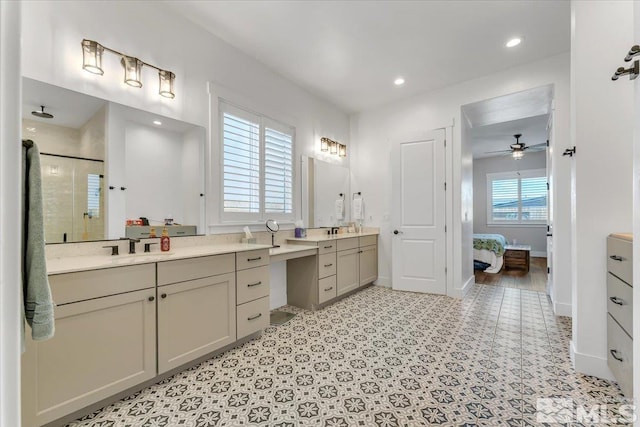 bathroom with ceiling fan, a healthy amount of sunlight, walk in shower, and vanity