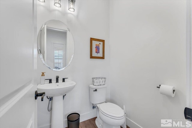 bathroom with hardwood / wood-style floors and toilet