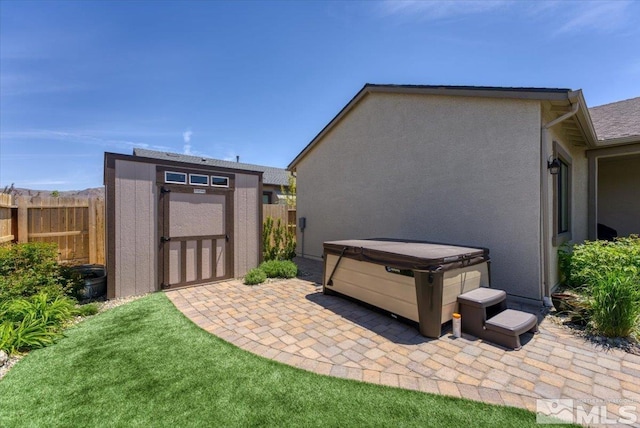 exterior space with a hot tub and a storage unit