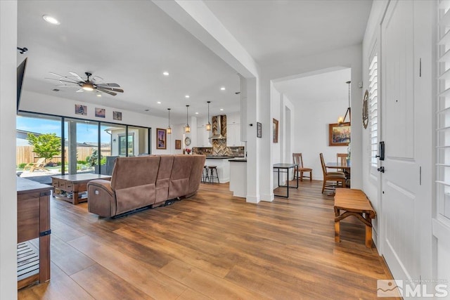 living room featuring ceiling fan and hardwood / wood-style floors