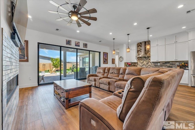 living room featuring ceiling fan and light wood-type flooring