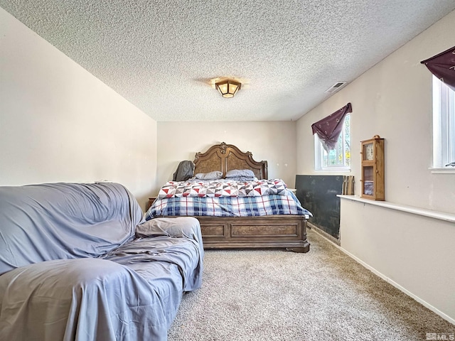 bedroom featuring light colored carpet and a textured ceiling