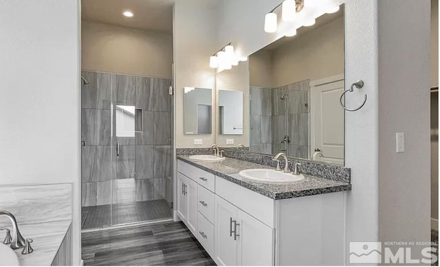 bathroom with a tile shower and vanity