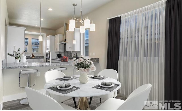 dining space with sink and a chandelier