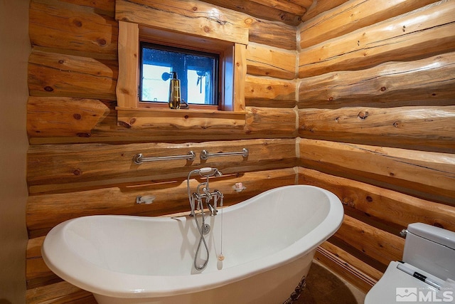 bathroom with toilet, rustic walls, and a bathtub