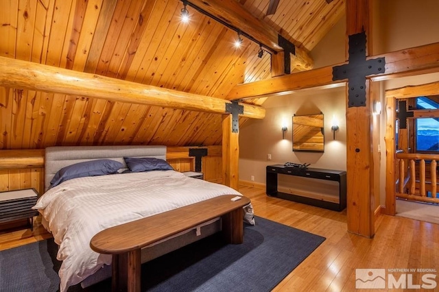 bedroom with vaulted ceiling with beams, wood ceiling, track lighting, and light hardwood / wood-style floors