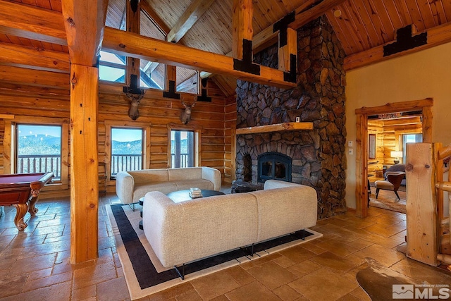 living room featuring rustic walls, beam ceiling, high vaulted ceiling, a stone fireplace, and wooden ceiling