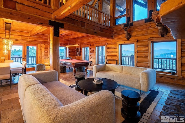 living room featuring a towering ceiling, billiards, beamed ceiling, a mountain view, and french doors