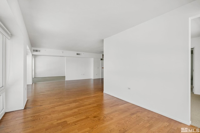 unfurnished room with visible vents, baseboards, and light wood finished floors