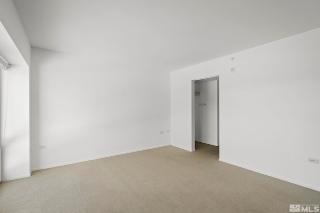 carpeted empty room featuring baseboards