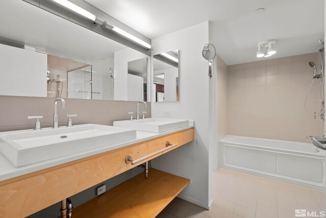 bathroom with tile floors, dual bowl vanity, tasteful backsplash, and tiled shower / bath combo