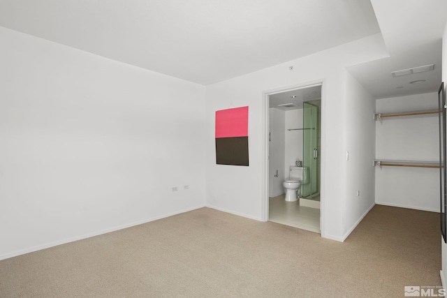 unfurnished bedroom featuring connected bathroom and carpet flooring