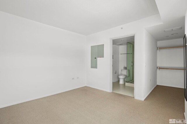 unfurnished bedroom with ensuite bathroom and carpet floors