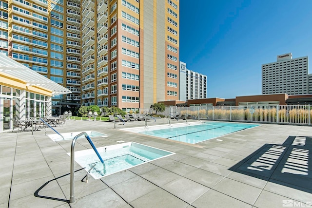 view of swimming pool with a hot tub