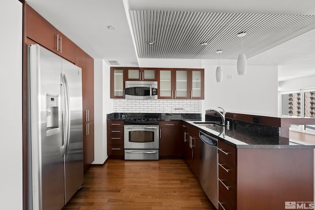 kitchen featuring sink, backsplash, hardwood / wood-style floors, and stainless steel appliances