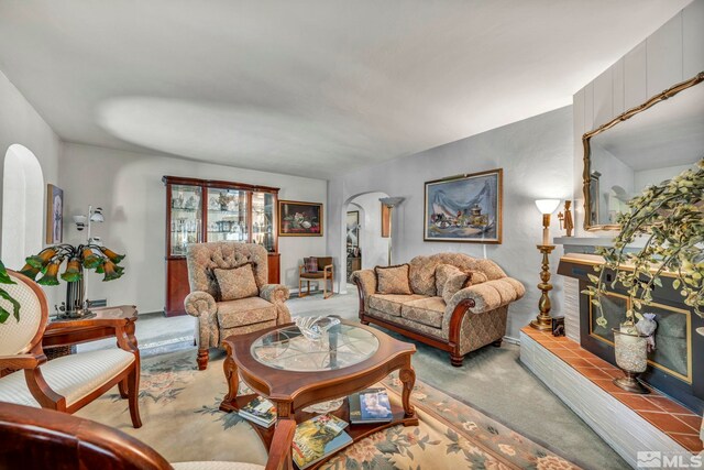 living room with carpet floors and a tiled fireplace