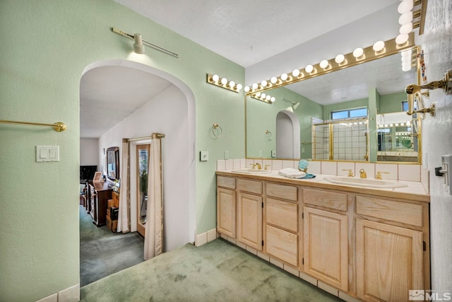 bathroom featuring vanity and a shower with door