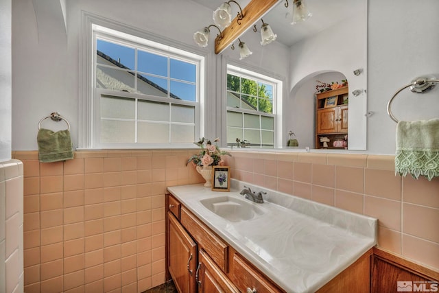 bathroom with vanity and tile walls