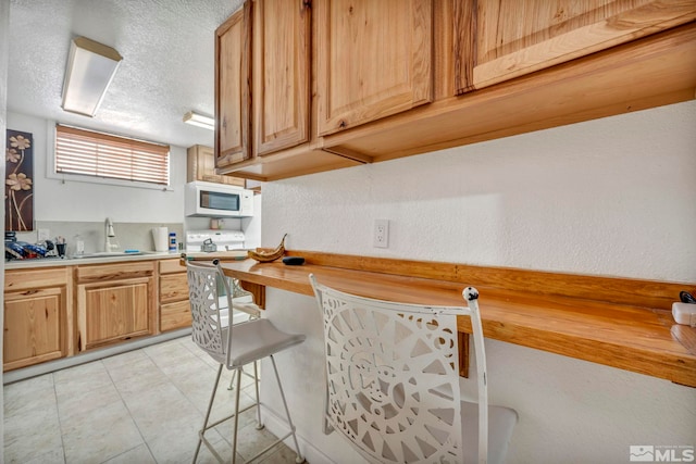 kitchen featuring wood counters, a textured ceiling, and sink