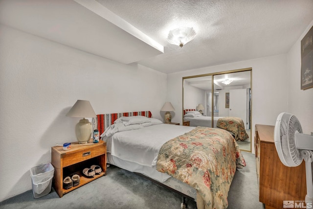 bedroom with carpet floors, a textured ceiling, and a closet