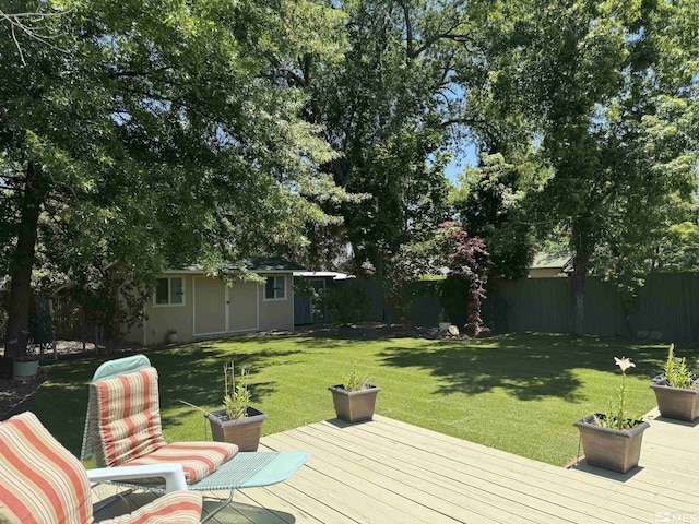 wooden terrace with an outdoor structure and a lawn