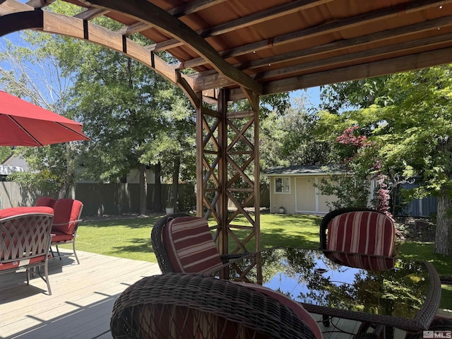 wooden deck featuring a lawn and an outbuilding